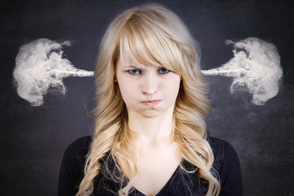 Angry young woman, blowing steam coming out of ears