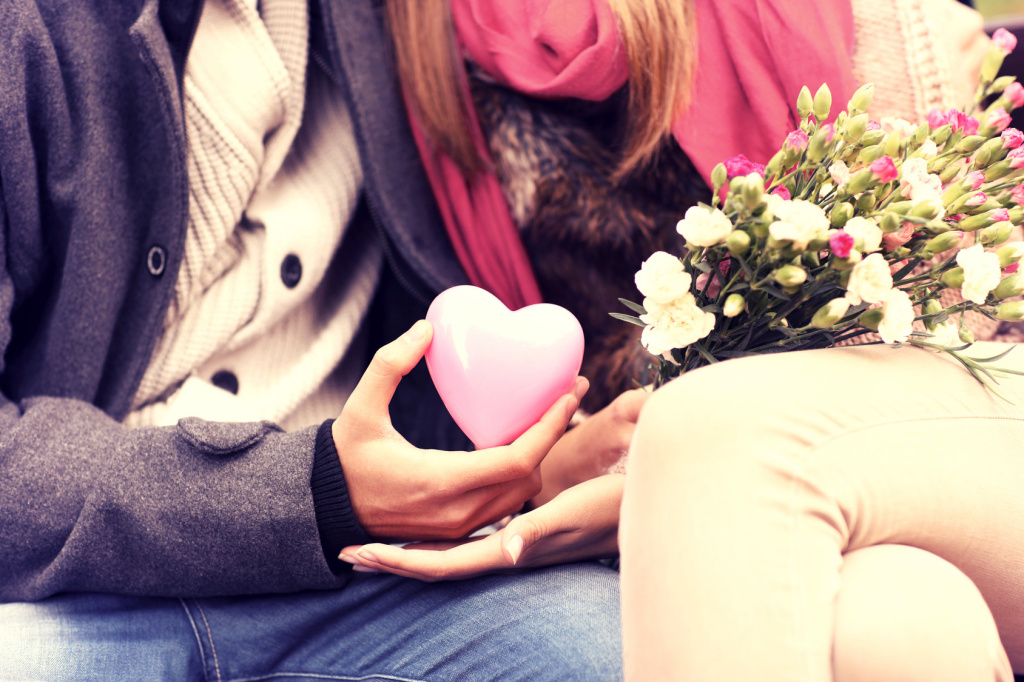 Midsection of a romantic couple sitting on a bench